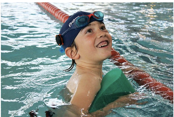 Child in a pool with Nagi tag attached to swimmers cap